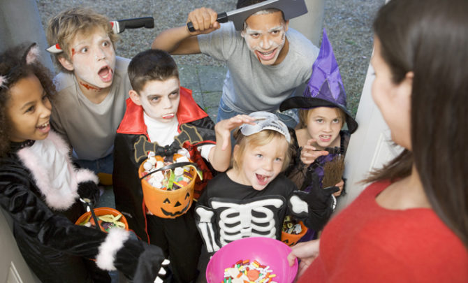 Six children in costumes trick or treating at woman's house
